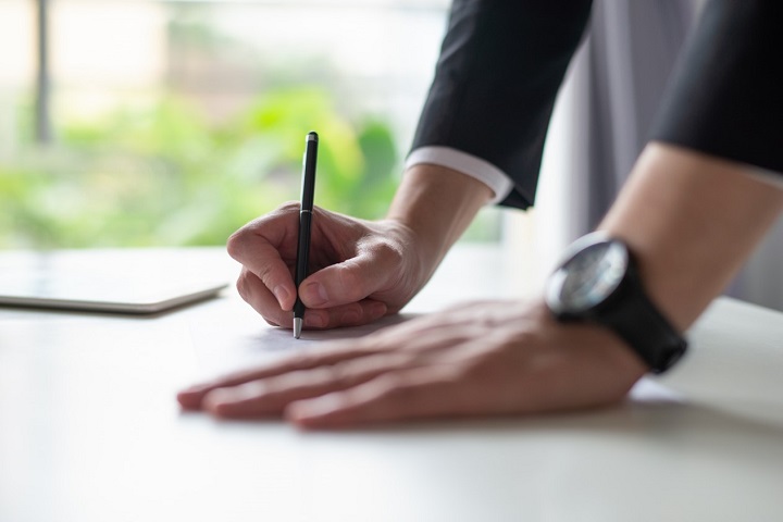 Image d'une personne signant un document